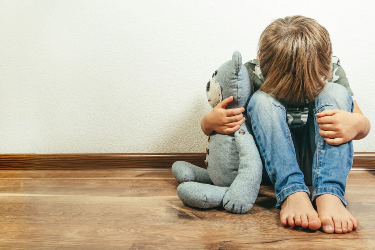 Child holding bear stuffed animal