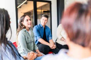 Mid adult woman introducing herself in group therapy at mental health center