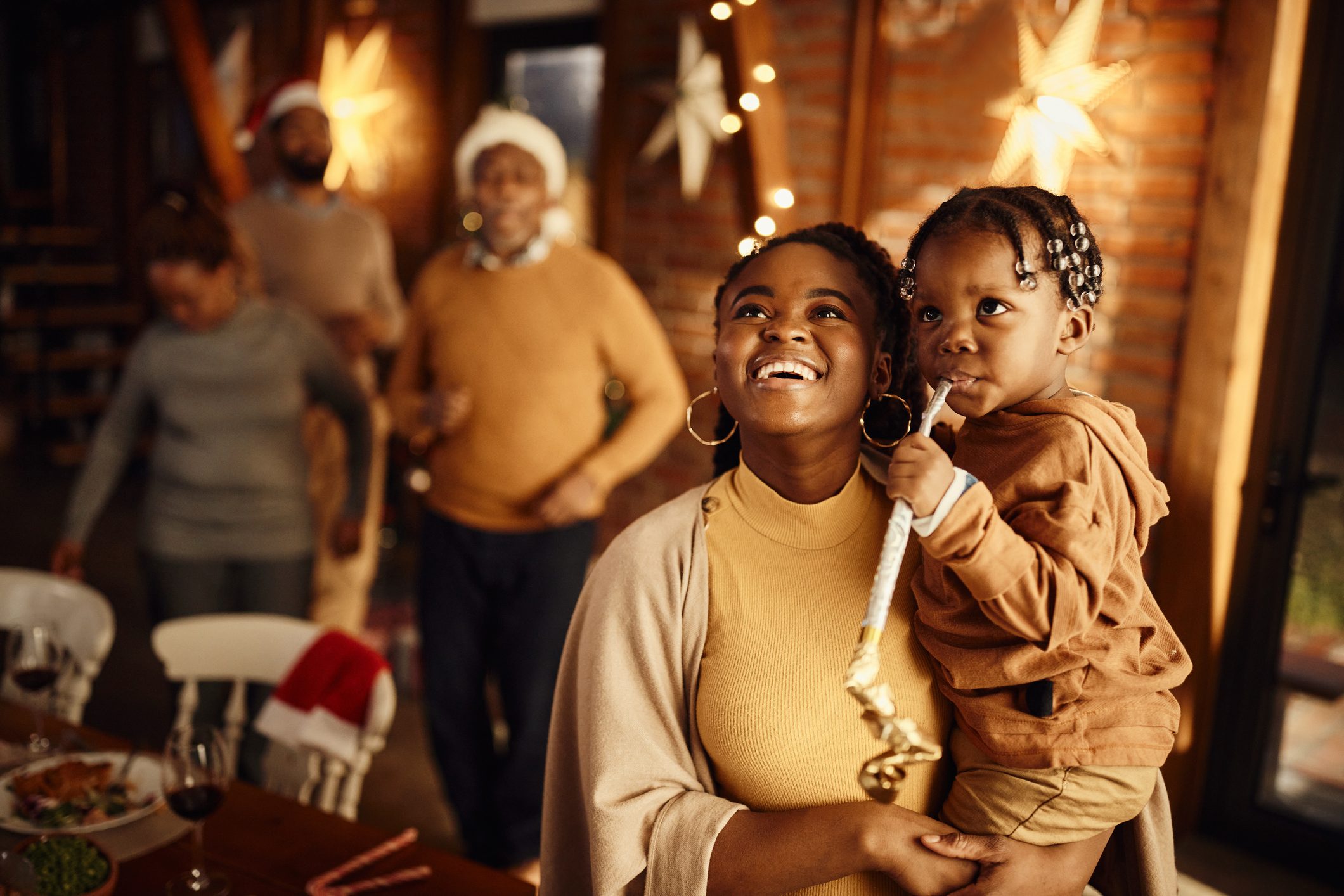 Happy African American mother and son celebrating Christmas at home.